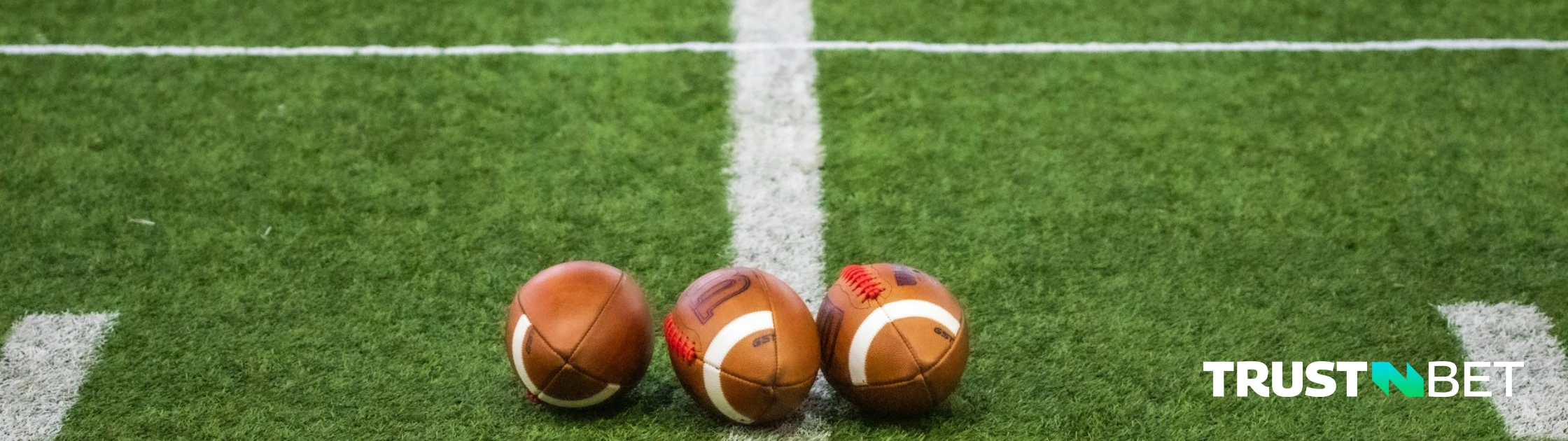 American footballs lined up on a field.